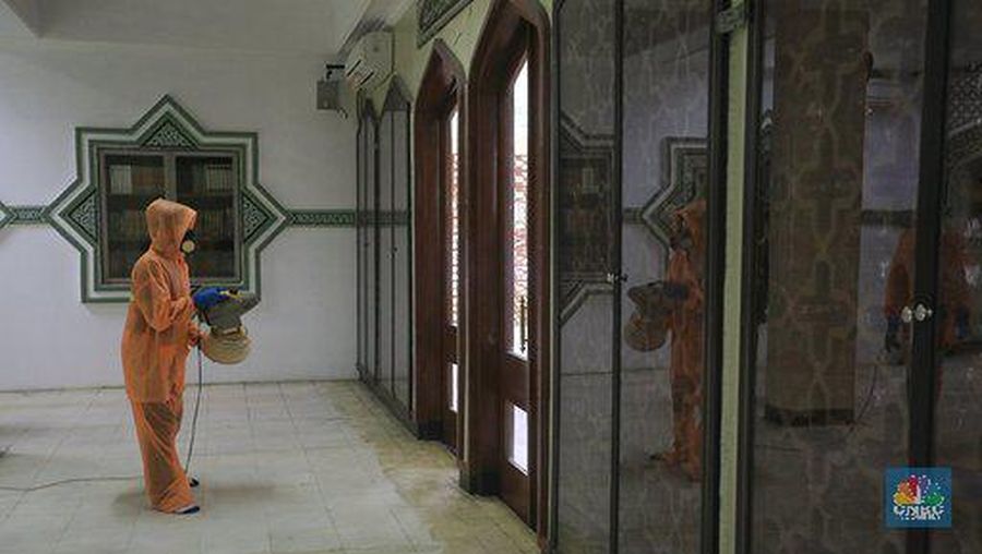 Petugas tata lingkungan Taman Mini Indonesia Indah menyemprotkan cairan disinfektan.