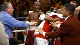Roger Mayweather tanpa ragu bergulat dengan Zab Judah dan sejumlah krunya. Pihak keamanan harus turun tangan melerai perkelahian ini. (Photo by Al Bello/Getty Images/AFP)