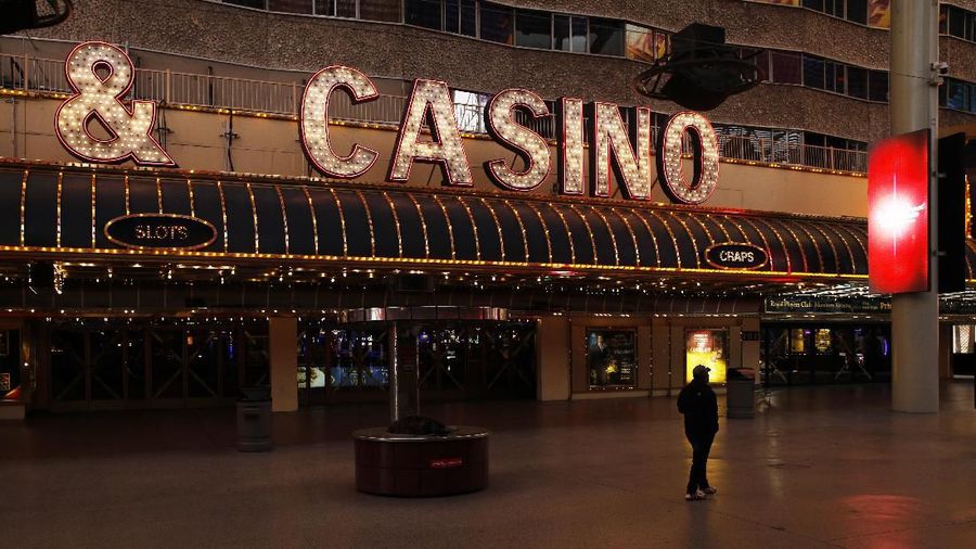 Kasino di Fremont Street (AP Photo/John Locher) A person walks along Fremont Street devoid of the usual crowds after casinos have been ordered to shut down due to the coronavirus Wednesday, March 18, 2020, in Las Vegas. For most people, the new coronavirus causes only mild or moderate symptoms, such as fever and cough. For some, especially older adults and people with existing health problems, it can cause more severe illness, including pneumonia. (AP Photo/John Locher)