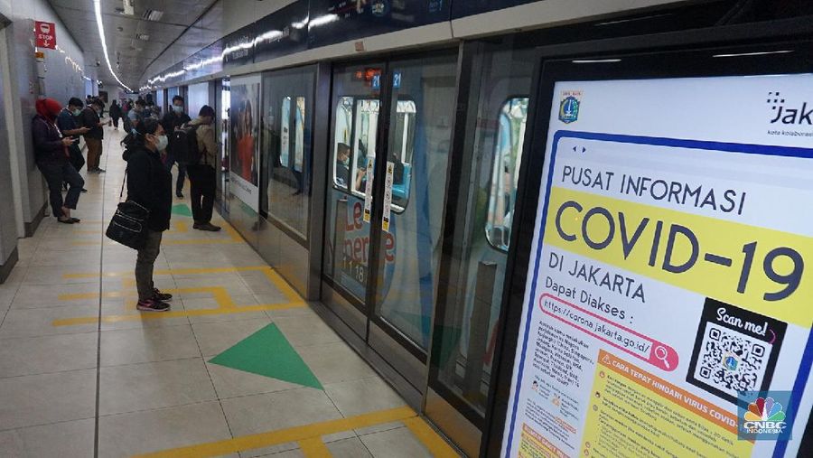 Pengunjung MRT duduk di bangku yang telah diberi stiker panduan jarak 