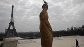 Seorang pria berjalan di lapangan Trocadero di depan menara Eiffel, Paris, yang sepi karena wabah corona. (AP/Christophe Ena)