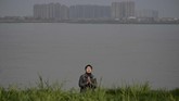 Seorang umat Buddha berdoa sebelum melepas kura-kura dan ikan ke sungai di Juijiang, Provinsi Jiangxi, China. (AFP Noel Celis)