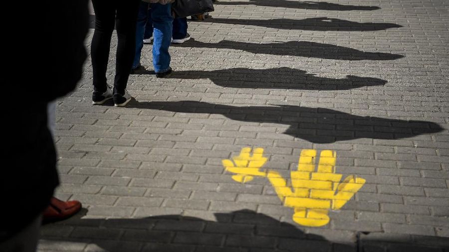 People keep their distance as they queue up in front of a post office in Debrecen, Hungary, March 16, 2020. (Zsolt Czegledi/MTI via AP)