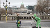 Orang-orang berkostum mengambil gambar di Dublin untuk perayaan St. Patrick. Parade St.Patrick dibatalkan di seluruh Iralandia karena wabah virus corona (Covid-19). (AP/Peter Morrison)