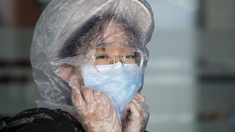 A Chinese woman uses a plastic bag to cover her head while waiting for her flight at the departure area of Manila's International Airport, Philippines, Wednesday, March 18, 2020. The Philippine government lifted a 72-hour deadline for thousands of foreign travelers to leave the country's main northern region which has been placed under quarantine due to the growing number of coronavirus infections, officials said. For most people, the new coronavirus causes only mild or moderate symptoms. For some, it can cause more severe illness, especially in older adults and people with existing health problems. (AP Photo/Aaron Favila)