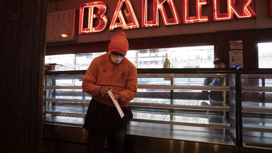 An employee of Junior's Restaurant picks up a paycheck, Thursday, March 19, 2020 in the Brooklyn borough of New York. The restaurant company, which has closed its four locations due to the coronavirus, has laid off 650 of 850 employees. (AP Photo/Mark Lennihan)