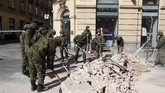 Ketika gempa reda, tentara Kroasia membersihkan reruntuhan bangunan di jalanan. (AP Photo/Darko Bandic)