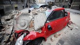 Mobil hancur karena tertimpa reruntuhan gedung yang diguncang gempa di pusat kota Zagreb, Kroasia. Gempa terjadi pada Minggu (22/3) pukul enam pagi waktu setempat, ketika warga baru memulai aktivitas. (Photo by Damir SENCAR / AFP)