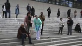 Seorang perawat memeriksa seorang pria yang pingsan saat menanti tes corona di Marseille. Bagi sebagian orang, virus ini hanya menyebabkan gejala ringan seperti batuk-batuk, tapi bagi yang lainnya bisa menyebabkan sakit parah hingga sesak napas. (AP Photo/Daniel Cole)