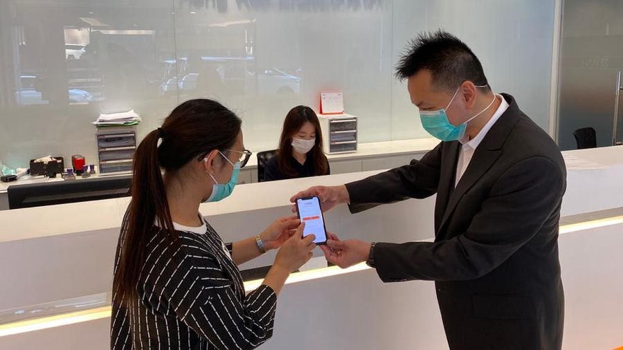 Seorang pegawai sedang membantu nasabah untuk melakukan aktivasi BNI Mobile Banking di BNI Hong Kong pada Selasa (24 Maret 2020). (Dok. BNI)