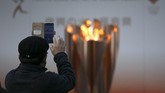 Tanpa pawai obor bukan berarti tak ada masyarakat yang ingin mengabadikan momen spesial khas menyambut Olimpiade. (AP Photo/Jae C. Hong)