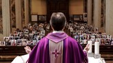 Don Giuseppe Corbari, pastur dari Gereja Robbiano, mengadakan misa pada Minggu lalu sembari menatap foto-foto selfie dari jemaatnnya. (Piero CRUCIATTI / AFP)