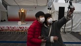 Antusiasme masyarakat menyambut api Olimpiade tetap terlihat. Swafoto menjadi ciri khas kekinian untuk mengabadikan sebuah momen penting. (AP Photo/Jae C. Hong)
