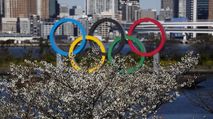 Olimpiade Tokyo (AP Photo/Jae C. Hong) The Olympic rings floating on a barge are seen behind cherry blossoms Wednesday, March 25, 2020, in the Odaiba section of Tokyo. Not even the Summer Olympics could withstand the force of the coronavirus. After weeks of hedging, the IOC took the unprecedented step of postponing the world's biggest sporting event, a global extravaganza that's been cemented into the calendar for more than a century. (AP Photo/Jae C. Hong)