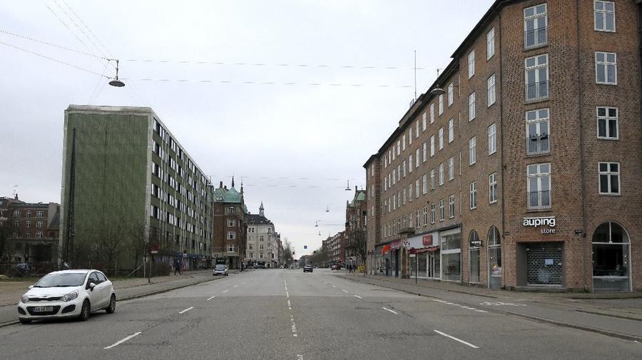 Oesterbrogade, a normally busy Copenhagen boulevard with lots of traffic is seen empty on Wednesday March 18, 2020. As of Wednesday, Denmark has banned the gathering of 10 or more people in the public room and non-food stores, restaurants and cafes will stay close. Food stores and pharmacies remain open. For most people, the new coronavirus causes only mild or moderate symptoms. For some it can cause more severe illness, especially in older adults and people with existing health problems. (AP Photos/Jan M. Olsen)