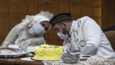 Yavuz Ozdemir dan Irra Chorina Octora yang menggelar pernikahan di tengah penyebaran wabah virus corona berbicara dengan mengenakan masker, Rabu (25/3). (Juni Kriswanto / AFP).