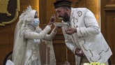 Pengantin wanita asal Indonesia Irra Chorina Octora menyuapi suaminya Yavuz Ozdemir dengan mengenakan masker di tengah pernikahan yang dilaksanakan di Surabaya, Rabu (25/3) demi mencegah penularan virus corona. (Juni Kriswanto / AFP).