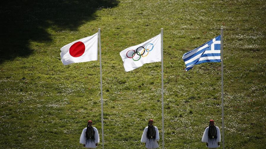 Greek Evzones guards stand next to Japan, Olympic and Greece flags, from left, during the flame lighting ceremony at the closed Ancient Olympia site, birthplace of the ancient Olympics in southern Greece, Thursday, March 12, 2020, 2020. Greek Olympic officials are holding a pared-down flame-lighting ceremony for the Tokyo Games due to concerns over the spread of the coronavirus. Both Wednesday's dress rehearsal and Thursday's lighting ceremony are closed to the public, while organizers have slashed the number of officials from the International Olympic Committee and the Tokyo Organizing Committee, as well as journalists at the flame-lighting. (AP Photo/Yorgos Karahalis)