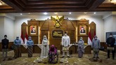 Anggota keluarga Yavuz Ozdemir dan Irra Chorina Octora berdiri dengan mengenakan masker di pernikahan yang mereka langsungkan di tengah wabah virus corona di Surabaya, Rabu (25/3). (Juni Kriswanto / AFP).
