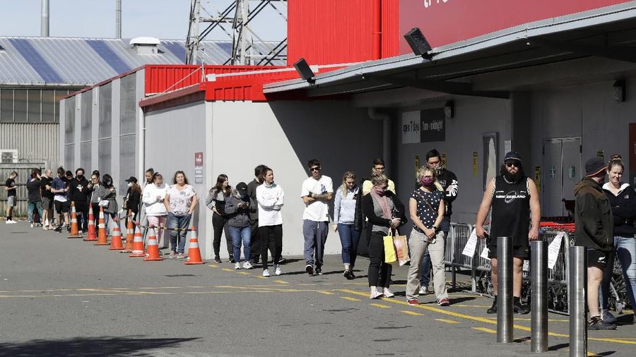 Customers queue to enter a department store in Christchurch, New Zealand, Wednesday, March 25, 2020. New Zealand will close schools and non-essential services at midnight on Wednesday as the country goes into lockdown to try to stop the spread of coronavirus pandemic. For most people, the new coronavirus causes only mild or moderate symptoms. For some it can cause more severe illness. (AP Photo/Mark Baker)