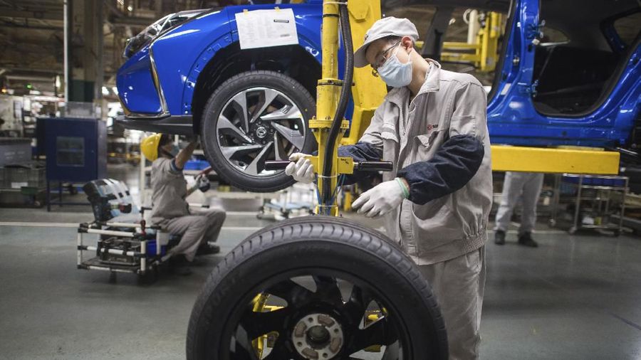 In this photo released by Xinhua News Agency, workers labor at an assembly line for Dongfeng Passenger Vehicle Company in Wuhan, in central China's Hubei Province, March 24, 2020. While many migrant workers across China remain trapped by travel bans due to the coronavirus, some industrial production has returned to action, including in the crucial auto manufacturing industry, which is largely based in Wuhan, and in businesses that provide critical links in global supply chains. (Xiao Yijiu/Xinhua via AP)