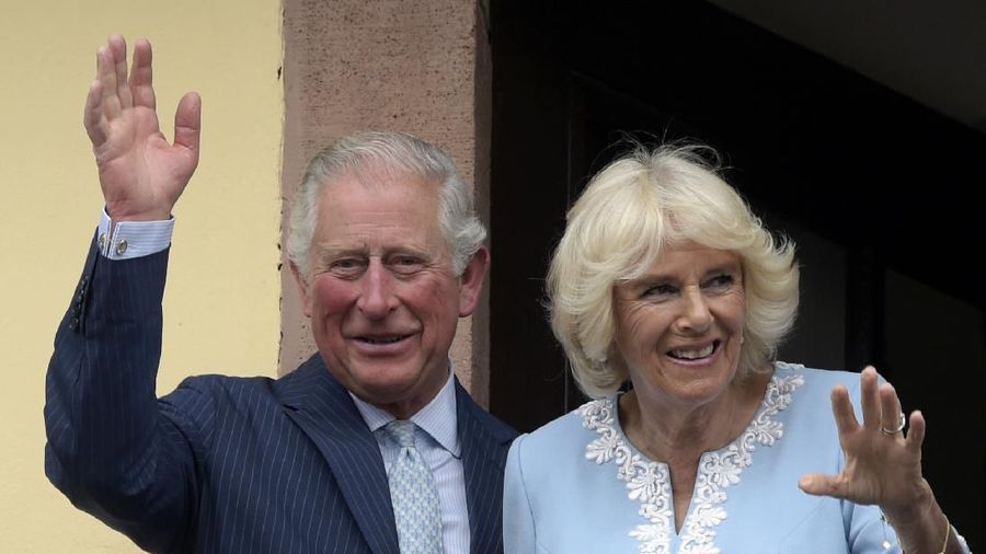 FILE - In this Wednesday, May 8, 2019 file photo, Britain's Prince Charles and Camilla, Duchess of Cornwall wave from the town hall balcony in Leipzig, Germany. Prince Charles, the heir to the British throne, has tested positive for the new coronavirus. The prince’s Clarence House office reported on Wednesday, March 25, 2020 that the 71-year-old is showing mild symptoms of COVID-19 and is self-isolating at a royal estate in Scotland. It says his wife Camilla has tested negative. (AP Photo/Jens Meyer, File)
