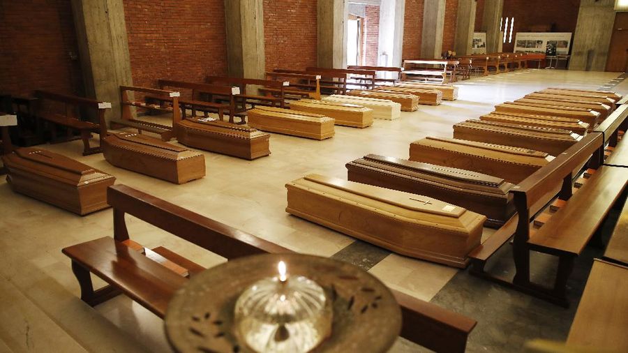 Coffins are lined up on the floor of the San Giuseppe church in Seriate, Italy, one of the regions worst hit by coronavirus, near Bergamo, waiting to be taken to a crematory, Thursday, March 26, 2020. (AP Photo/Antonio Calanni)