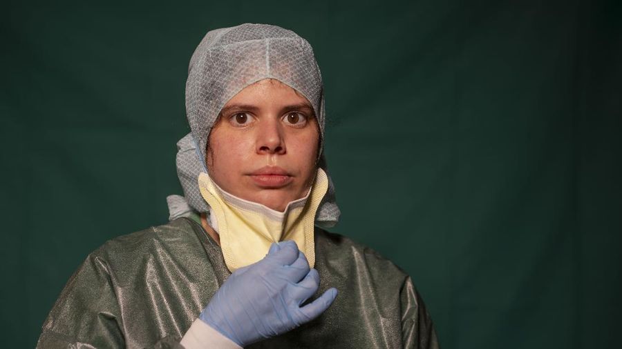 Claudia Accardo, ICU transport service at Rome's COVID 3 Spoke Casalpalocco Clinic, poses for a portrait, Friday, March 27, 2020, during a break in her daily shift. The intensive care doctors and nurses on the front lines of the coronavirus pandemic in Italy are almost unrecognizable behind their masks, scrubs, gloves and hairnets. But that flimsy battle armor donned at the start of each shift is their only barrier to contagion. (AP Photo/Domenico Stinellis)