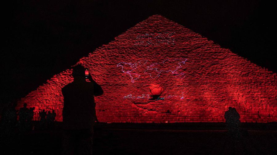 The Ministry of antiquities lights up the pyramids in an expression of support for health workers battling the coronavirus outbreak, Monday, March 30, 2020, in Giza, Egypt. (AP Photo/Nariman El-Mofty)