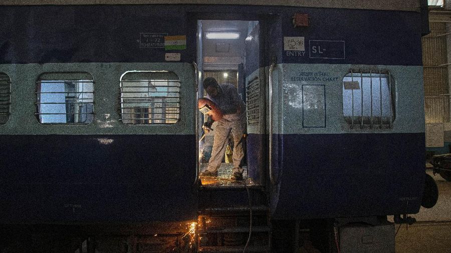 An Indian railway employee works to convert a train coach into an isolation ward for the fight against the new coronavirus in Gauhati, India, Sunday, March 29, 2020. Indian Prime Minister Narendra Modi apologized to the public on Sunday for imposing a three-week national lockdown, calling it harsh but 