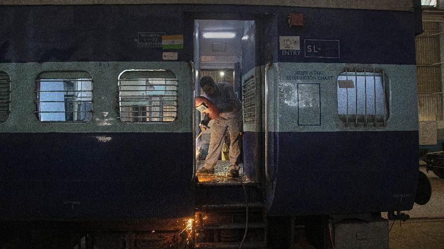 An Indian railway employee works to convert a train coach into an isolation ward for the fight against the new coronavirus in Gauhati, India, Sunday, March 29, 2020. Indian Prime Minister Narendra Modi apologized to the public on Sunday for imposing a three-week national lockdown, calling it harsh but