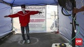 Memanfaatkan kipas angin uap air, sebuah perumahan mengharuskan pendatang masuk ke bilik sterilisasi disinfektan sebelum masuk ke perumahan warga. (CNNIndonesia/Safir Makki)