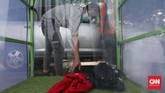 Orang yang masuk bilik disinfektan wajib melepaskan semua barang bawaannya seperti tas, jaket, helm, untuk disemprot disinfektan. (CNNIndonesia/Safir Makki)