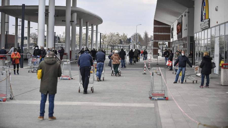 People line up outside a supermarket in Bergamo, one of the northern Italian areas worse affected by coronavirus, Wednesday, March 25, 2020. The new coronavirus causes mild or moderate symptoms for most people, but for some, especially older adults and people with existing health problems, it can cause more severe illness or death. (Claudio Furlan/LaPresse via AP)