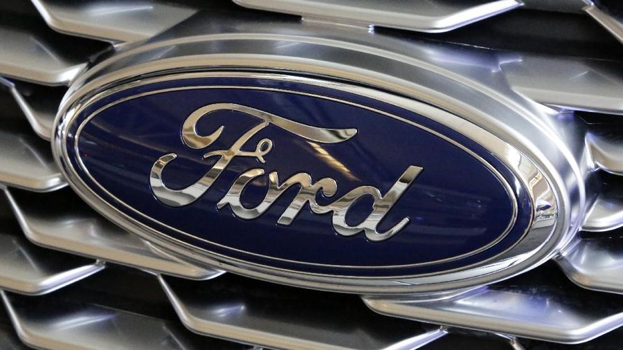 FILE - This Feb. 15, 2018 photo shows a Ford logo on display at the Pittsburgh Auto Show in Pittsburgh. Ford is recalling more than 268,000 cars in North America, on Wednesday, March 25, 2020  to fix doors that could open unexpectedly or may not close. The recall covers the 2014 through 2016 Ford Fusion and Lincoln MKZ, and the 2014 and 2015 Ford Fiesta.  (AP Photo/Gene J. Puskar)