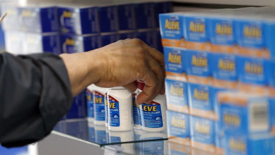 In this Wednesday, May 13, 2015, photo, an employee stocks products in the employee shop at the Bayer Pharmaceuticals facility in Whippany, N.J. Bayer now markets 170 consumer health products, 17 with annual sales topping $100 million. Those include Bayers own One A Day and Flintstones vitamins, Aleve pain reliever, Alka-Seltzer and Phillips' Colon Health, plus former Merck products including Claritin, Coppertone and Dr. Scholls foot products. (AP Photo/Julio Cortez)