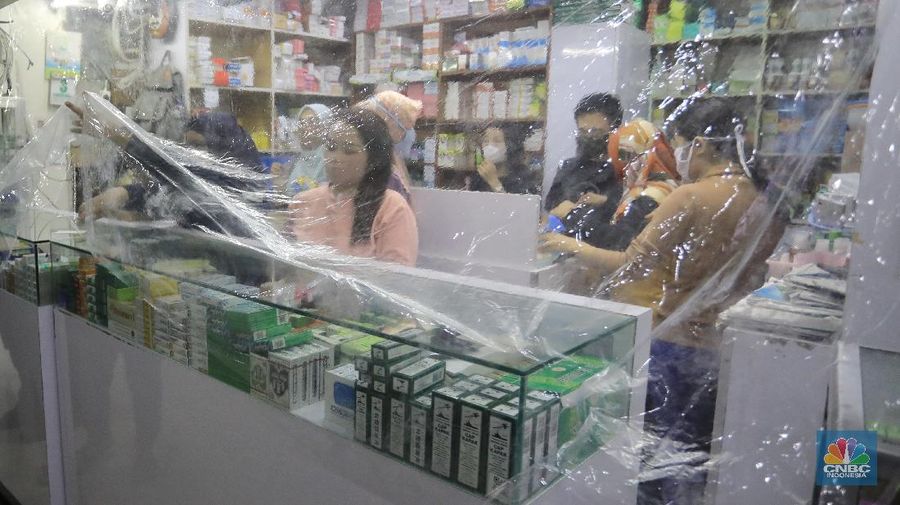 Begini penampakan toko Apotek di Pasar Baru, Jakarta, yang menutupi tokonya dengan tirai plastik untuk transaksi jual beli.
