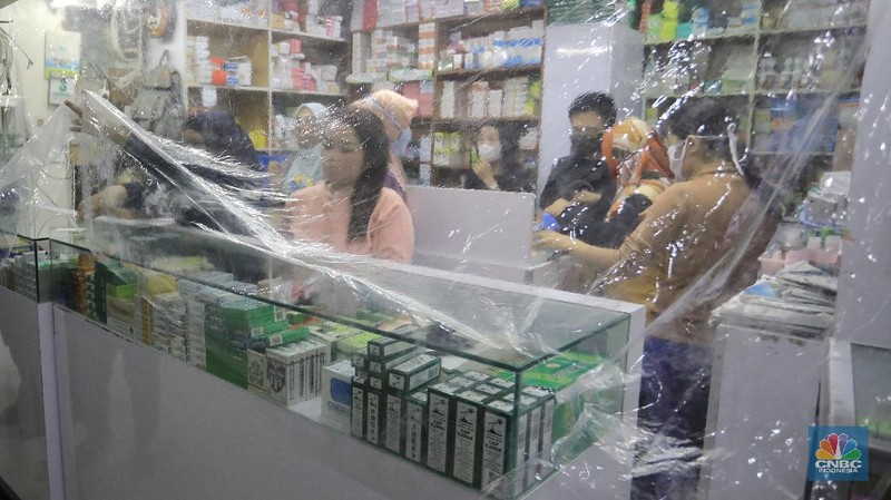 Begini penampakan toko Apotek di Pasar Baru, Jakarta, yang menutupi tokonya dengan tirai plastik untuk transaksi jual beli.