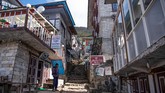 Seorang pria berdiri di jalanan kosong dekat toko-toko yang tutup di Namche Bazar. Selain menutup diri dari turis asing, Nepal juga menerapkan lockdown total di seluruh di negeri. (Photo by PRAKASH MATHEMA / AFP)