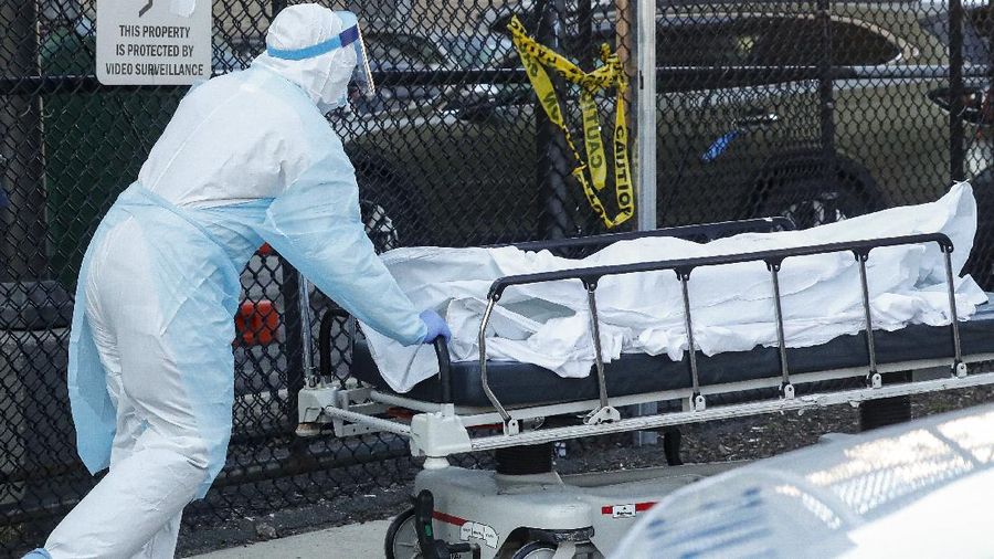 A medical worker wearing personal protective equipment wheels a body to a refrigerated trailer serving as a makeshift morgue at Wyckoff Heights Medical Center, Monday, April 6, 2020, in the Brooklyn borough of New York. The new coronavirus causes mild or moderate symptoms for most people, but for some, especially older adults and people with existing health problems, it can cause more severe illness or death. (AP Photo/John Minchillo)