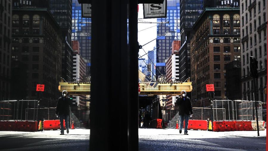 A person wearing a protective face mask walks in New York, Monday, April 6, 2020, during the current coronavirus outbreak. (AP Photo/Matt Rourke)
