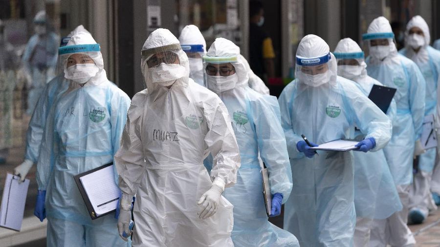 Medical workers in protective suits entering a building under lockdown in downtown Kuala Lumpur, Malaysia, on Tuesday, April 7, 2020. The Malaysian government issued a restricted movement order to the public to help curb the spread of the new coronavirus. The new coronavirus causes mild or moderate symptoms for most people, but for some, especially older adults and people with existing health problems, it can cause more severe illness or death. (AP Photo/Vincent Thian)
