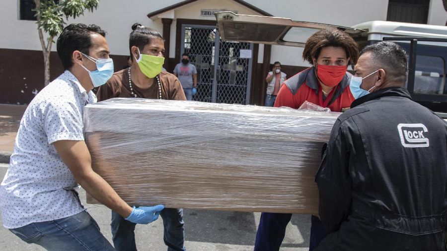 Relatives carry the remains of a loved one in a cardboard coffin for burial, as they leave a church in Guayaquil, Ecuador, Monday, April 6, 2020. Guayaquil, a normally bustling city that has become a hot spot in Latin America as the coronavirus pandemic spreads, also has untold numbers dying of unrelated diseases that can’t be treated because hospitals are overwhelmed. (AP Photo/Luis Perez)