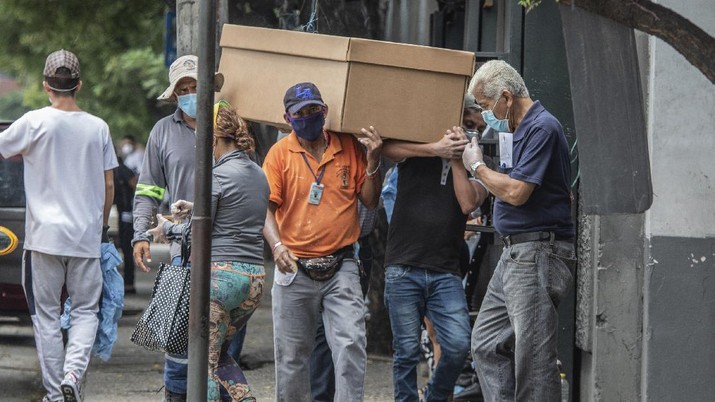 Warga membawa jenazah pasien Covid-19 dengan peti mati terbuat dari kardus (AP/Luis Perez) Cemetery workers carry the remains of a person in a cardboard coffin for burial at the General Cemetery in Guayaquil, Ecuador, Monday, April 6, 2020. Guayaquil, a normally bustling city that has become a hot spot in Latin America as the coronavirus pandemic spreads, has untold numbers dying of unrelated diseases that can’t be treated because hospitals are overwhelmed. (AP Photo/Luis Perez)