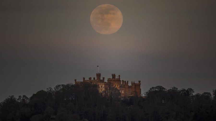 A pink supermoon is seen over Belvoir castle in Leicestershire, England, Tuesday, April 7, 2020. The phenomenon of