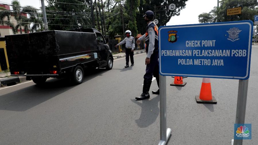 Polisi lalu lintas dan Dishub melaksanakan pengawasan dalam penerapan pembatasan sosial berskala besar (PSBB) di Jalan Lebak Bulus, Jakarta Selatan (10/4/2020). Polantas dan Dishub menyetop bagi pengendara motor atau mobil yang tidak menggunakan masker dan mengingatkan kewajiban warga untuk memakai masker dan aturan penumpang dalam satu kendaraan. (CNBC Indonesia/Muhammad Sabki)