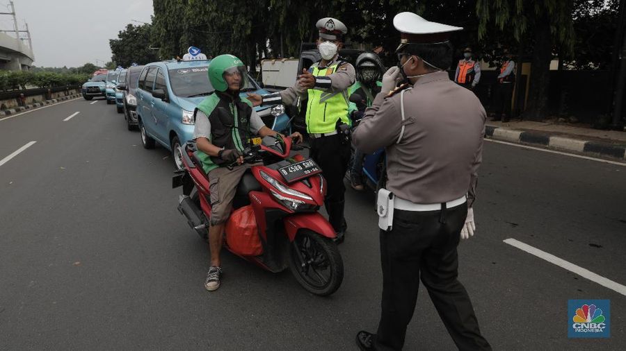 Polisi lalu lintas dan Dishub melaksanakan pengawasan dalam penerapan pembatasan sosial berskala besar (PSBB) di Jalan Lebak Bulus, Jakarta Selatan (10/4/2020). Polantas dan Dishub menyetop bagi pengendara motor atau mobil yang tidak menggunakan masker dan mengingatkan kewajiban warga untuk memakai masker dan aturan penumpang dalam satu kendaraan. (CNBC Indonesia/Muhammad Sabki)