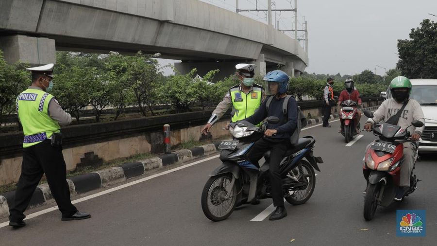 Polisi lalu lintas dan Dishub melaksanakan pengawasan dalam penerapan pembatasan sosial berskala besar (PSBB) di Jalan Lebak Bulus, Jakarta Selatan (10/4/2020). Polantas dan Dishub menyetop bagi pengendara motor atau mobil yang tidak menggunakan masker dan mengingatkan kewajiban warga untuk memakai masker dan aturan penumpang dalam satu kendaraan. (CNBC Indonesia/Muhammad Sabki)