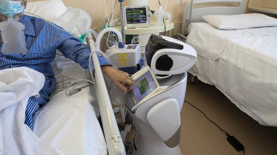 Deputy head of the intensive care unit Flavio Tangian, prepares a robot at 'Ospedale di Circolo' hospital, in Varese, Italy, Wednesday, April 8, 2020. Six robots will help healthcare professionals assist Covid-19 patients, one robot for every two patients to maximize monitoring and assistance. The new coronavirus causes mild or moderate symptoms for most people, but for some, especially older adults and people with existing health problems, it can cause more severe illness or death. (AP Photo/Luca Bruno)
