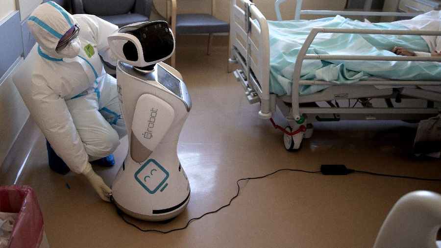 Deputy head of the intensive care unit Flavio Tangian, prepares a robot at 'Ospedale di Circolo' hospital, in Varese, Italy, Wednesday, April 8, 2020. Six robots will help healthcare professionals assist Covid-19 patients, one robot for every two patients to maximize monitoring and assistance. The new coronavirus causes mild or moderate symptoms for most people, but for some, especially older adults and people with existing health problems, it can cause more severe illness or death. (AP Photo/Luca Bruno)